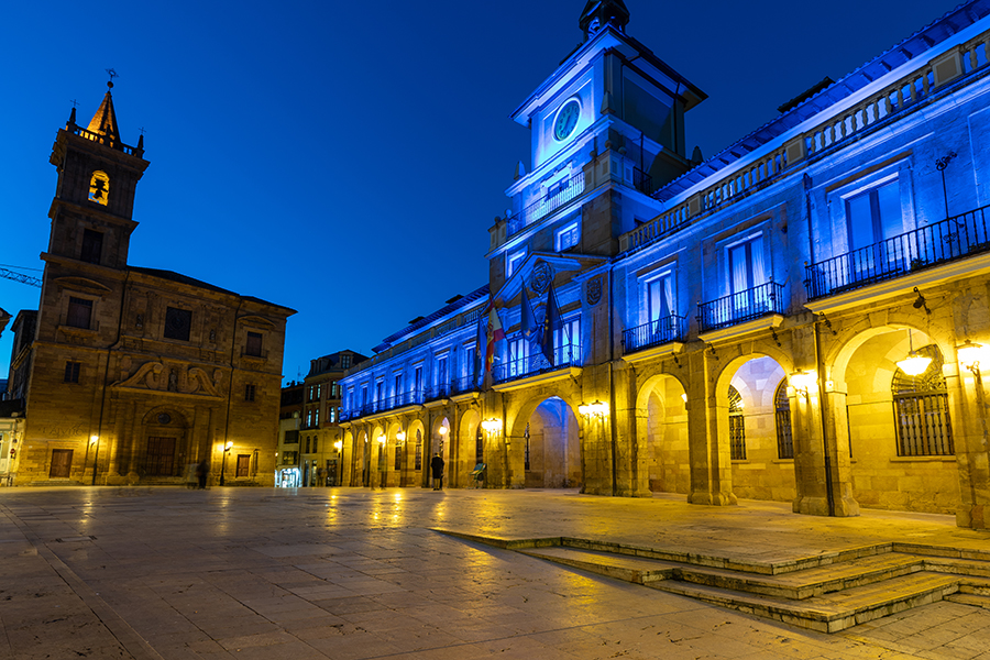Fachada de edificio histórico iluminado con color azul de la Policía Nacional